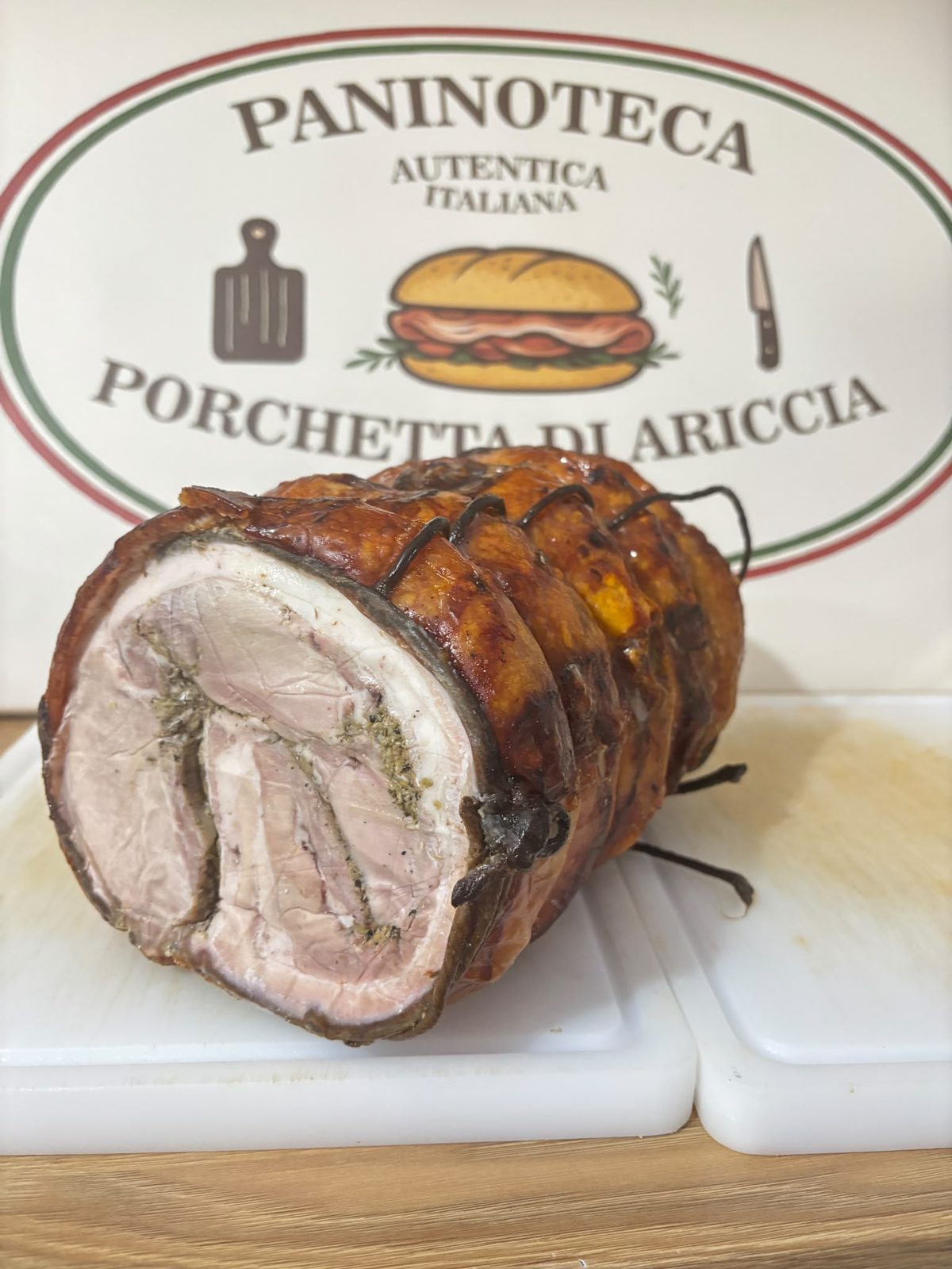 Porchetta di Ariccia tăiată, la tejghea, în fața siglei localului